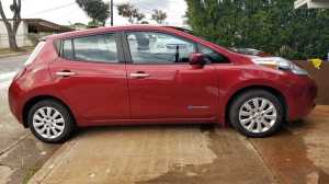 Image of a red 2015 Nissan Leaf in a driveway on Oahu. | The-Military-Guide.com