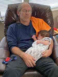 Image of Doug Nordman napping with his eight-week-old baby granddaughter Arya in his lap. | The-Military-Guide.com